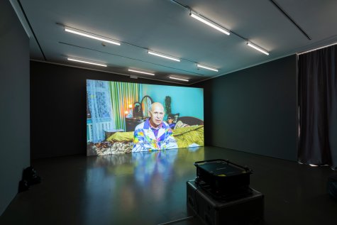 A dark room with beanbags and a projector projecting a movie onto the wall.