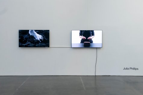 Two TVs hanging next to each other on a white wall.