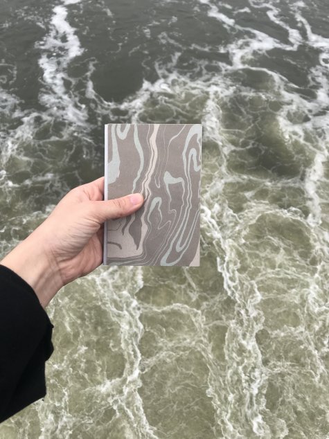 Buch mit Wellenmuster vor Wellen des Meeres